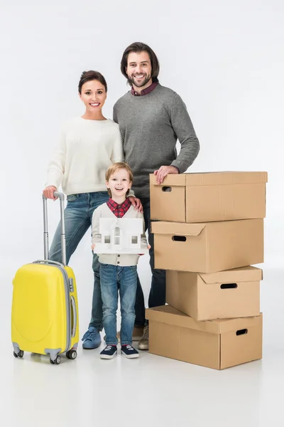 Мальчик держит картонный домик готовый переехать со своей семьей в новый дом изолированный на белом — стоковое фото