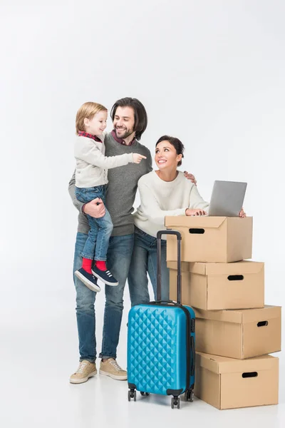 Familie mit Laptop auf Kartons und Sohn zeigt auf Laptop isoliert auf weiß — Stockfoto