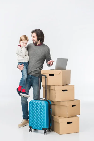 Father with son using laptop on cardboard boxes isolated on white — Stock Photo