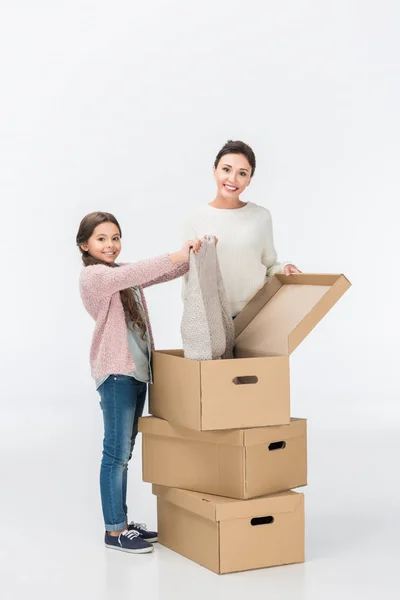 Happy mother and daughter with cardboard boxes moving to new house isolated on white — Stock Photo
