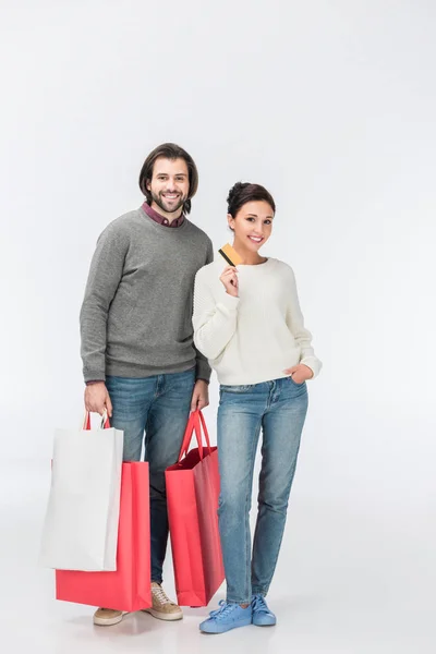 Hombre con bolsas de compras y mujer mostrando tarjeta de crédito aislada en blanco - foto de stock