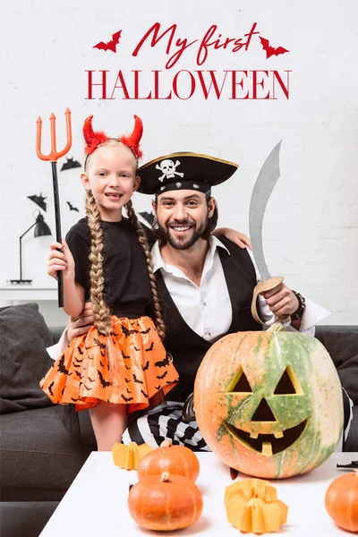 Счастливая дочь и отец в костюмах на Хэллоуин дома с надписью 