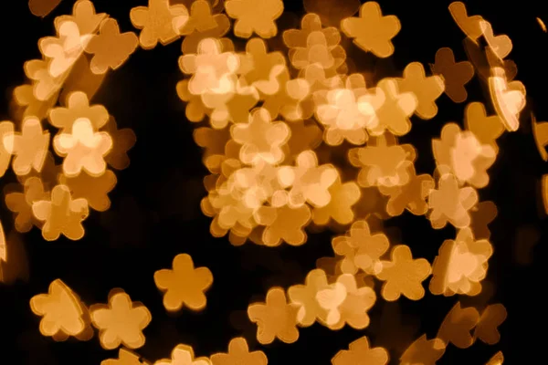 Vista de cerca de las estrellas doradas luces bokeh sobre fondo negro - foto de stock