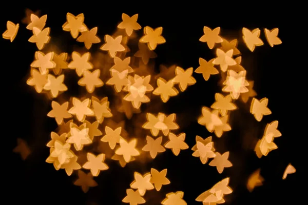 Full frame of golden stars bokeh lights on black background — Stock Photo