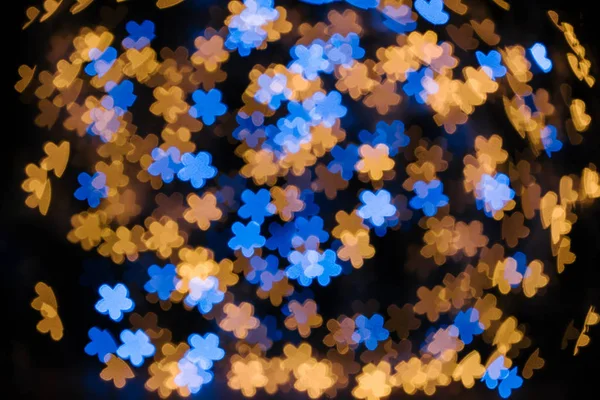 Full frame of shiny blue and golden stars bokeh lights on black backdrop — Stock Photo