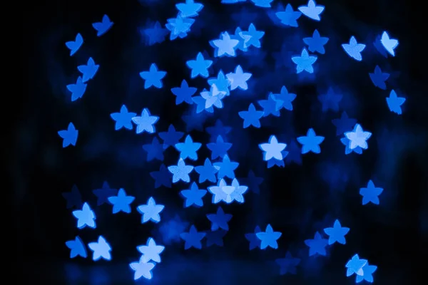 Hermosas estrellas azules bokeh sobre fondo negro - foto de stock