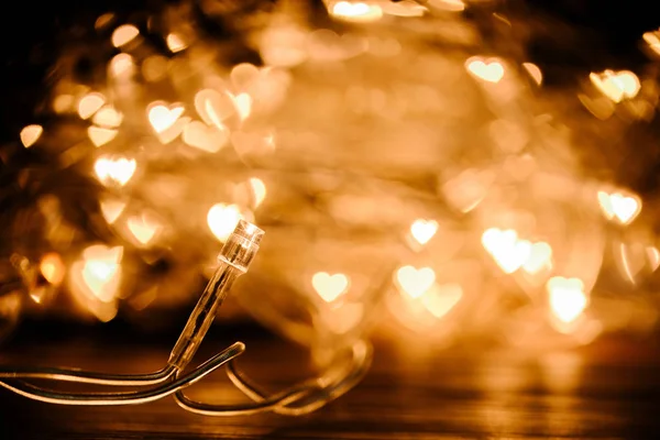 Close up view of festive garland and hearts bokeh lights backdrop — Stock Photo