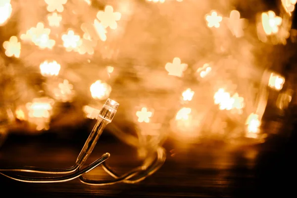 Close up view of festive garland and stars bokeh lights backdrop — Stock Photo