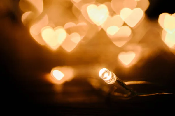 Close up view of festive garland and hearts bokeh lights backdrop — Stock Photo