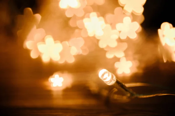 Close up view of festive garland and stars bokeh lights backdrop — Stock Photo