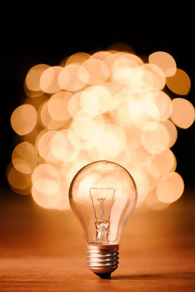 Close up view of light bulb and bokeh lights on background — Stock Photo