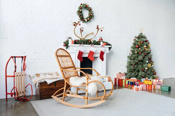 Chambre décorée avec fauteuil à bascule, arbre de Noël et cadeaux pour la célébration des vacances d'hiver — Photo de stock