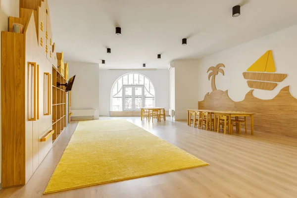 Salle de classe lumineuse confortable avec des meubles en bois dans la maternelle moderne — Photo de stock