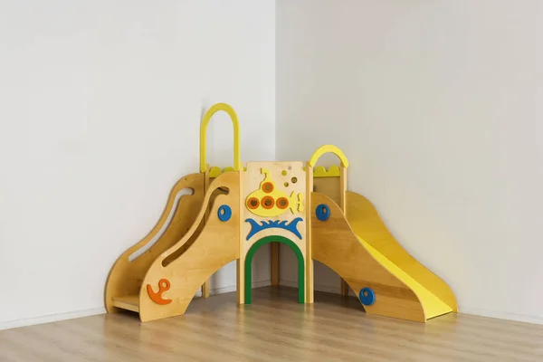 Schöne helle Holzrutschen im Spielzimmer des Kindergartens — Stockfoto