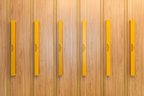 Vista de marco completo de armarios de madera con asas amarillas en el jardín de infantes - foto de stock