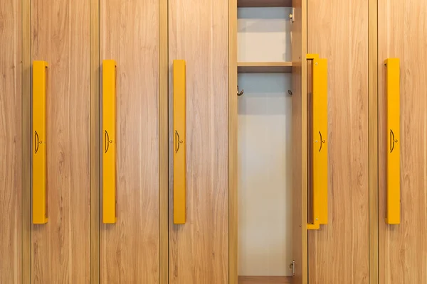 Casiers en bois avec poignées jaunes au vestiaire de la maternelle — Photo de stock