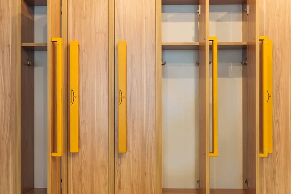 Vue plein cadre des casiers en bois avec poignées jaunes dans le vestiaire de la maternelle — Photo de stock