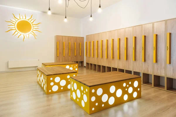 Wooden lockers in modern illuminated kindergarten cloakroom — Stock Photo