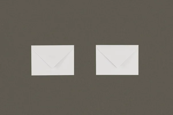 Close-up view of two white envelopes arranged isolated on grey background — Stock Photo