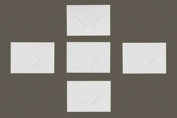 Top view of white envelopes arranged isolated on grey background — Stock Photo