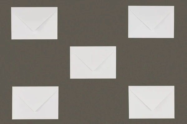 Vista de perto de envelopes brancos fechados isolados sobre fundo cinzento — Fotografia de Stock