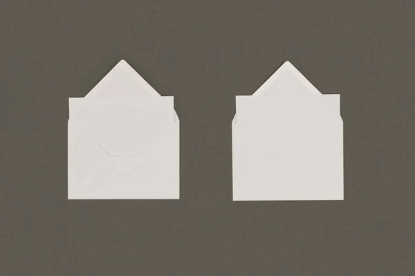 Верхний вид открытых белых конвертов с пустыми карточками, изолированными на сером — стоковое фото