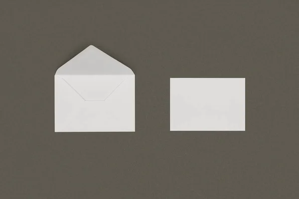 Vista ravvicinata della busta bianca aperta e della carta bianca isolata su sfondo grigio — Foto stock