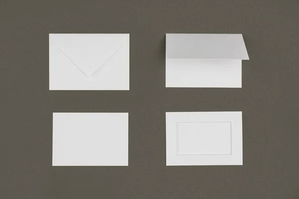 Draufsicht auf weiße Umschläge und Karten isoliert auf grau — Stockfoto