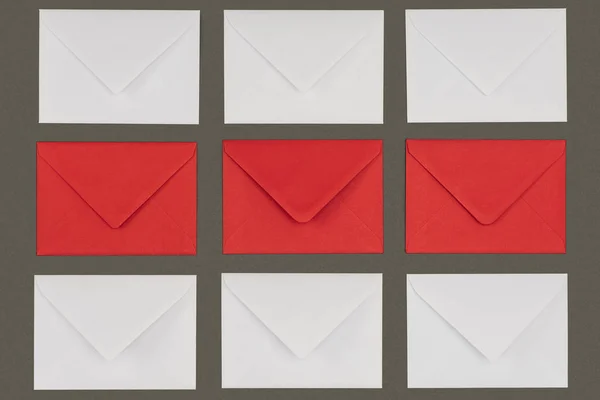 Vue de dessus des enveloppes fermées rouges et blanches isolées sur fond gris — Photo de stock