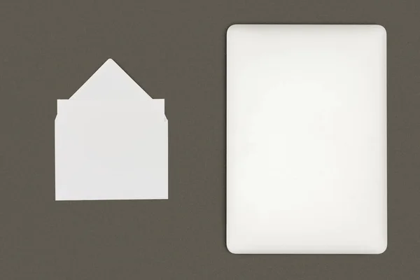 Vista superior de sobre blanco y tableta digital aislada en negro - foto de stock