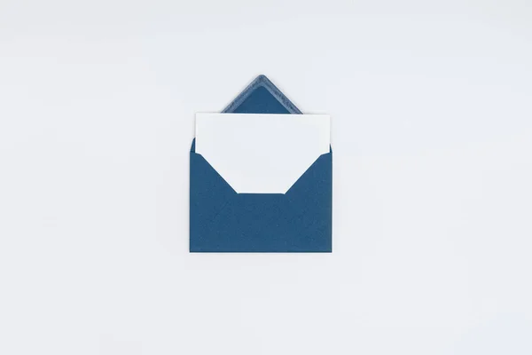 Close-up view of blue open envelope with blank white card isolated on white — Stock Photo