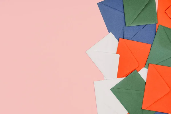 Vue de dessus des enveloppes colorées isolées sur fond rose — Photo de stock