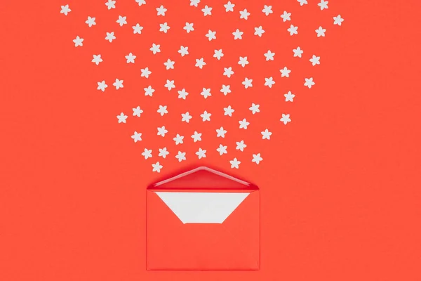 Close-up view of red envelope with blank card and small white stars isolated on red — Stock Photo