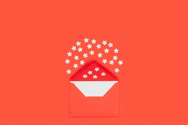 Top view of open red envelope with blank card and small white stars isolated on red — Stock Photo