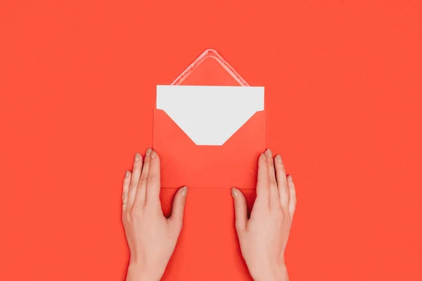 Tiro recortado de envelope de abertura pessoa com cartão isolado no vermelho — Fotografia de Stock