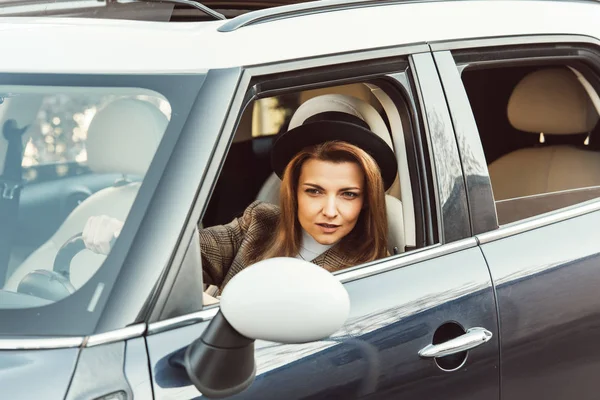 Foyer sélectif de la femme élégante adulte en veste à carreaux et chapeau noir voiture de conduite — Photo de stock