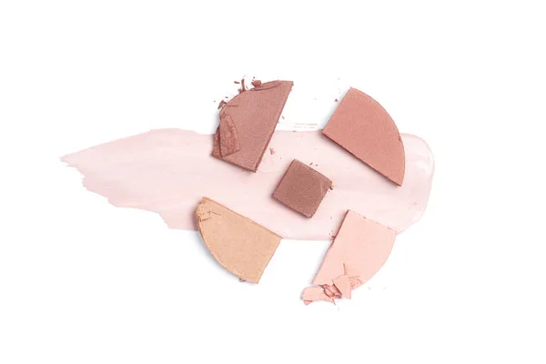 Vue de dessus du fard à joues de tons brun, rose et beige avec trait sur fond blanc — Photo de stock