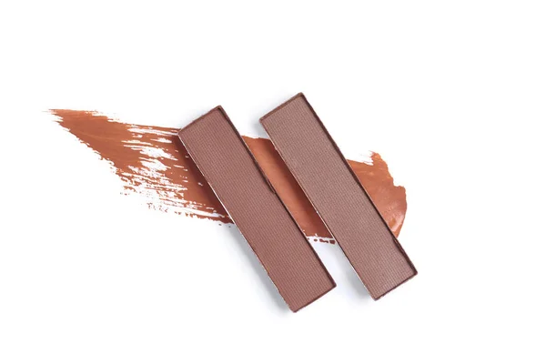 Top view of brown eyeshadows with stroke on white backdrop — Stock Photo