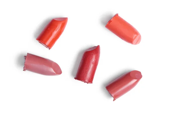 Vista superior de los lápices labiales cortados en diferentes colores sobre fondo blanco - foto de stock