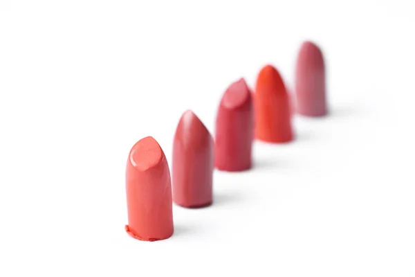 Close up view of cut lipsticks on different colors on white backdrop — Stock Photo