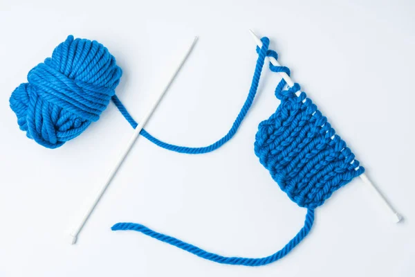 Vue de dessus des fils bleus et des aiguilles à tricoter sur fond blanc — Photo de stock
