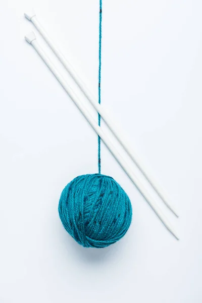 Vista superior de bola de fio azul e agulhas de tricô no fundo branco — Fotografia de Stock