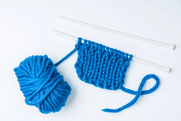 Vue de dessus des fils bleus et des aiguilles à tricoter sur fond blanc — Photo de stock