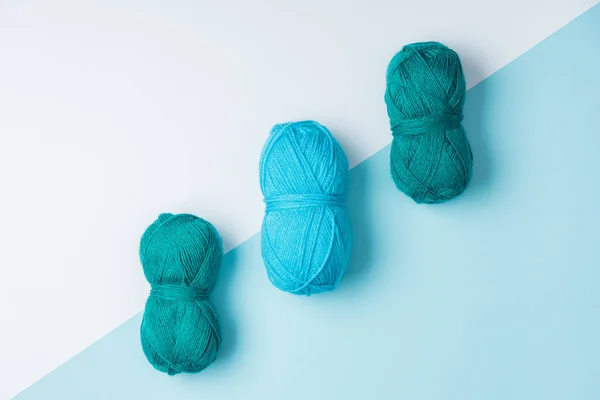 Flat lay with arranged blue yarn clews on white and blue background — Stock Photo