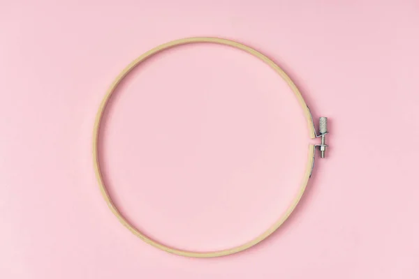 Top view of wooden embroidery hoop on pink background — Stock Photo
