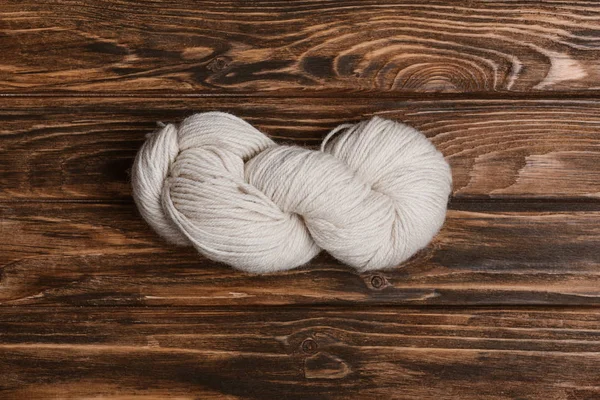 Vue de dessus du fil blanc pour tricoter sur la surface en bois — Photo de stock