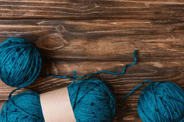 Flat lay with blue yarn clews on wooden surface — Stock Photo