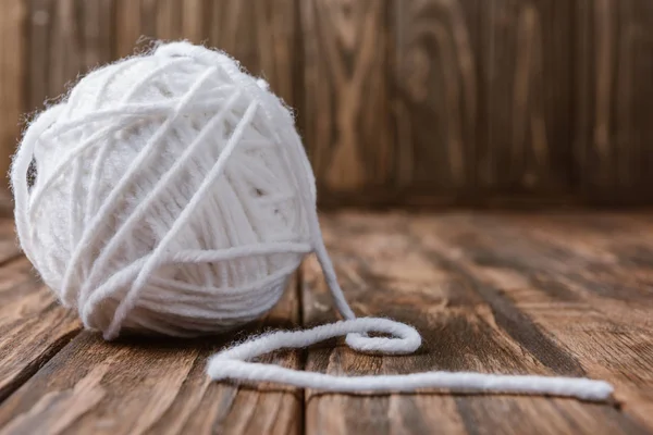 Close up view of white yarn clew on wooden surface — Stock Photo