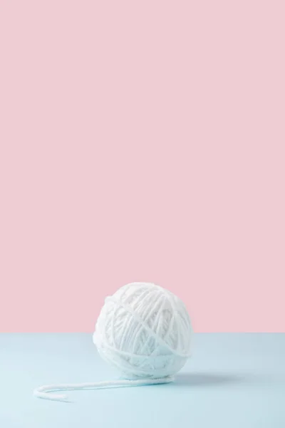 Nahaufnahme weißer Garnknäuel auf blauem und rosa Hintergrund — Stockfoto