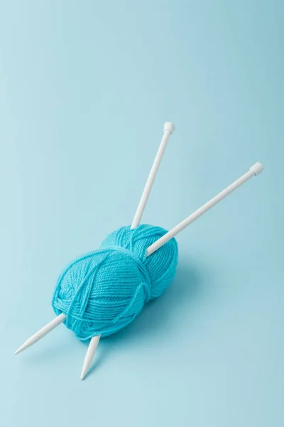 Close up vista de fio azul clew e agulhas de tricô no fundo azul — Fotografia de Stock